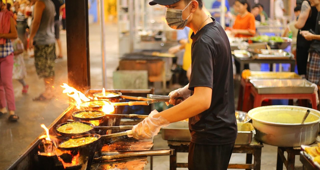 Food explorer enjoying street food at a vibrant Asian night market.